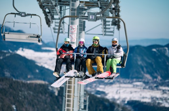 4 Personen sitzen in der Schneeberg Sesselbahn in Wintersportausr&uuml;stung